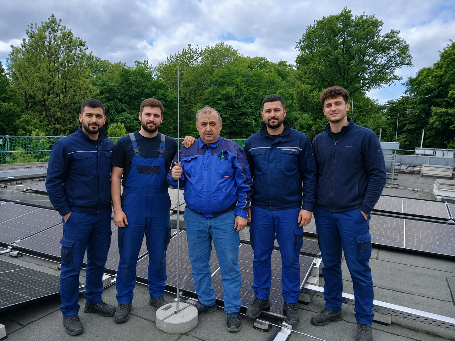 Das Team der Elektrotechnik H.A.K. GmbH auf einem Flachdach mit fertig montierter Photovoltaikanlage